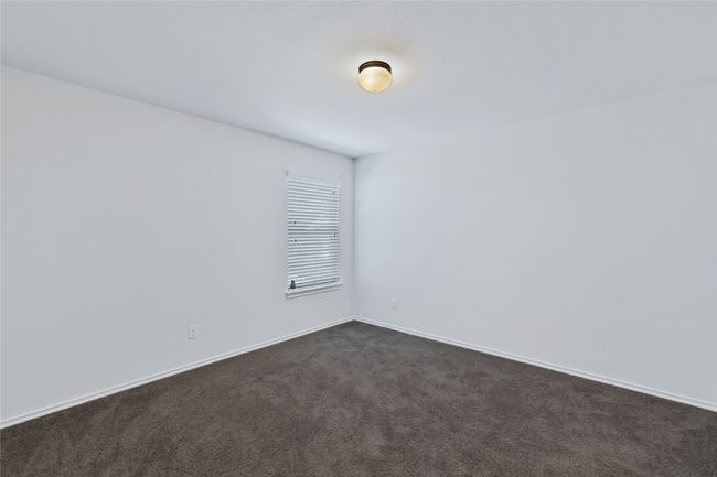Unfurnished room featuring dark colored carpet and baseboards | Image 24