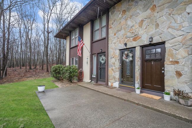 Entrance to property with stucco siding, stone siding, and a yard | Image 4