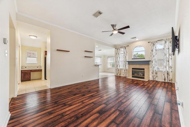 Family room with beautiful wood floors. Nice fireplace. Also you will see the desk area in the kitchen on the left. | Image 8