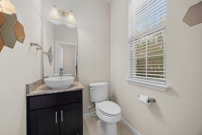 There's also a convenient main floor guest powder room with a granite topped vanity and raised bowl sink. | Image 24