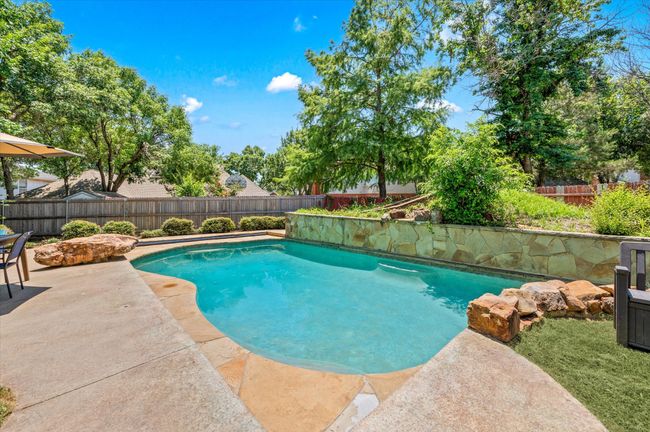 Another view of the pool! Surrounded by lush landscaping and plenty of grassy areas, you will find this backyard retreat to be a welcome escape from the hustle and bustle of your busy day! | Image 5