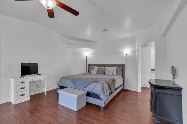 Bedroom featuring wood finished floors, vaulted ceiling, and a ceiling fan | Image 16