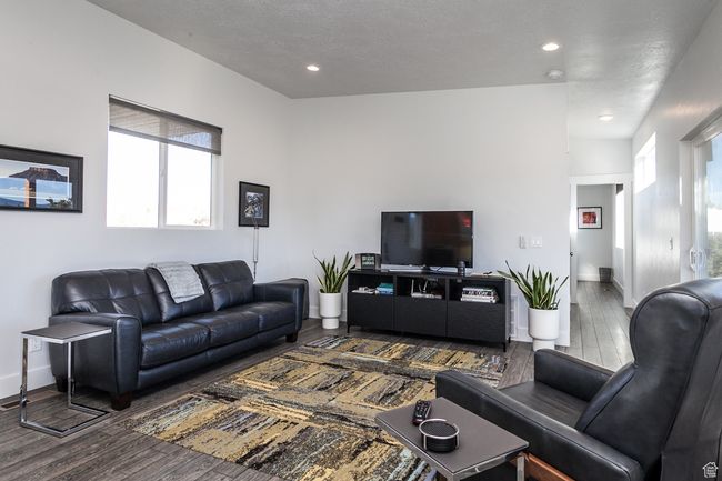 Living room featuring baseboards, a textured ceiling, recessed lighting, and dark wood-style flooring | Image 18