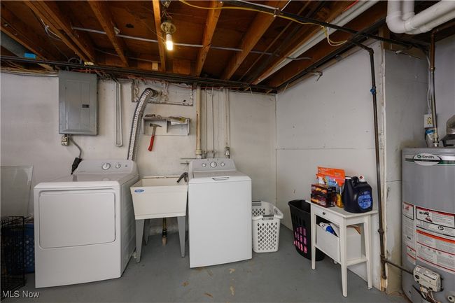 Unfinished basement featuring electric panel, water heater, and washing machine and dryer | Image 18