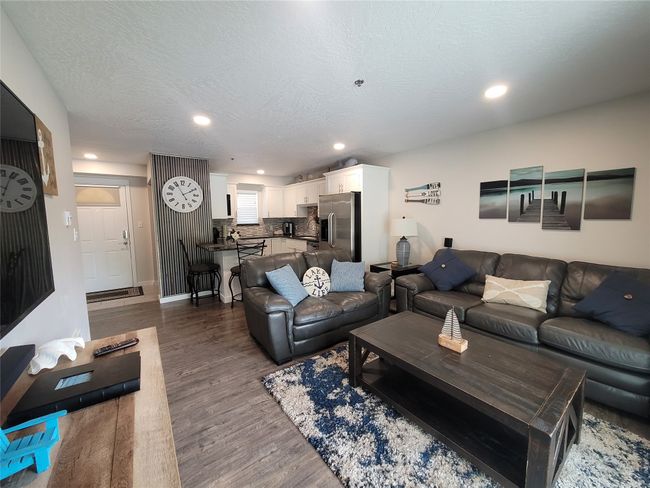 Living room with dark wood-type flooring and a textured ceiling | Image 8