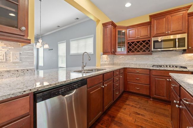 Kitchen with dark wood-style floors, appliances with stainless steel finishes, decorative backsplash, and a sink | Image 4
