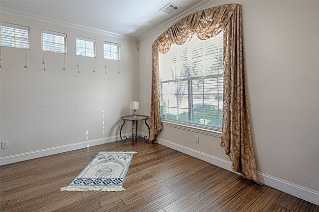 Spare room with ornamental molding, visible vents, baseboards, and wood finished floors | Image 7