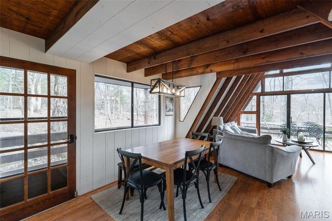 Dining room featuring beam ceiling, wooden walls, wood ceiling, and wood finished floors | Image 11