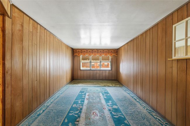 Carpeted empty room with wood walls | Image 9