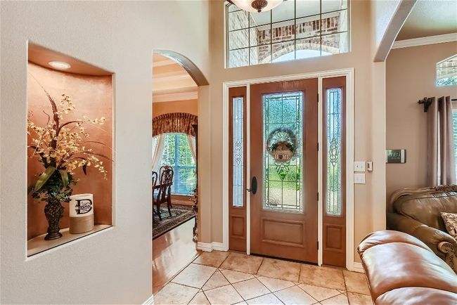 Entrance foyer with arched walkways, light tile patterned floors, baseboards, and ornamental molding | Image 4