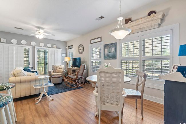Living area featuring wood finished floors, a wealth of natural light, and visible vents | Image 14