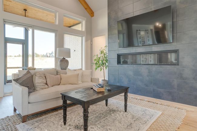 Living room with beamed ceiling, high vaulted ceiling, tile walls, and hardwood / wood-style flooring | Image 8