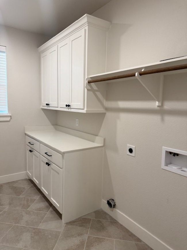 Washroom with cabinet space, hookup for an electric dryer, hookup for a washing machine, and light tile patterned floors | Image 28