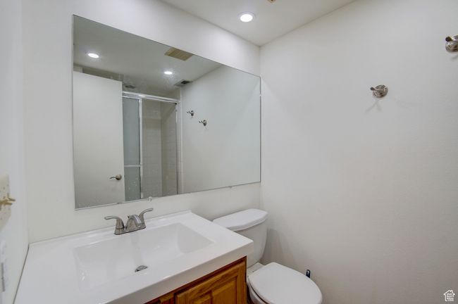 Bathroom with vanity, a shower with shower door, and toilet | Image 16