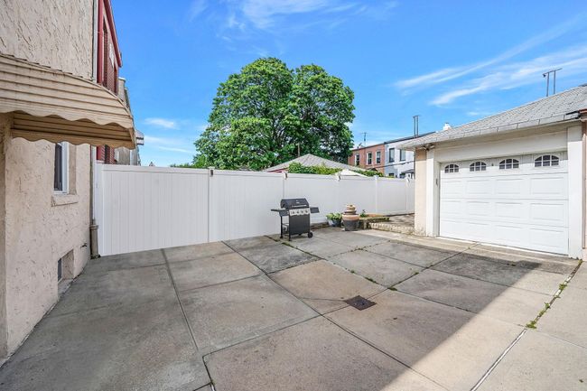 View of patio with grilling area, a garage, and concrete driveway | Image 21