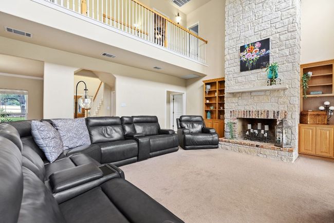 Family room with soaring ceilings and fireplace. Imagine these built-ins painted or stained. | Image 15