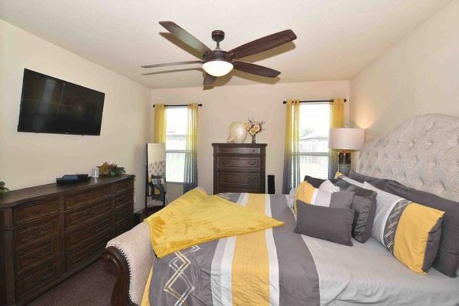 Carpeted bedroom with multiple windows and a ceiling fan | Image 18