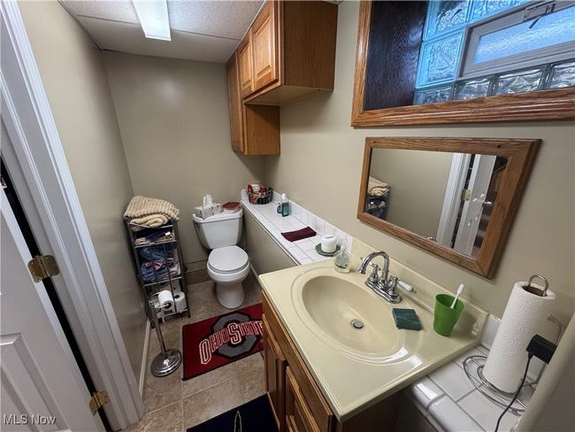 Bathroom with a drop ceiling, toilet, and vanity | Image 10