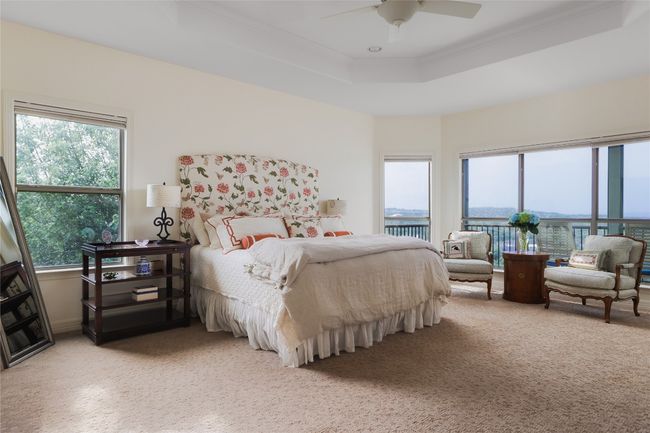 Bedroom with crown molding, a tray ceiling, light carpet, and ceiling fan | Image 27