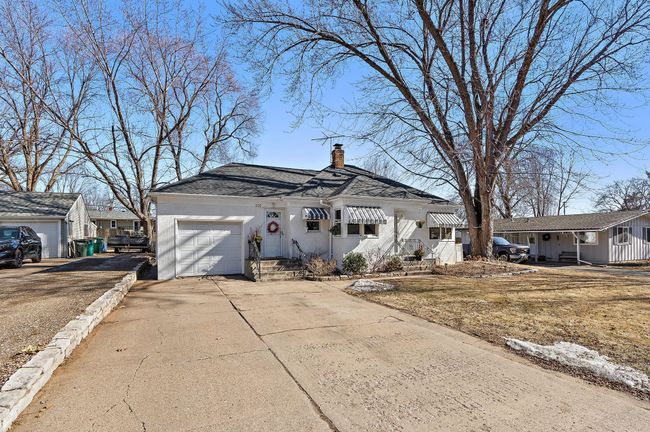 This quaint home features an attached garage and a concrete driveway for additional off street parking. | Image 32