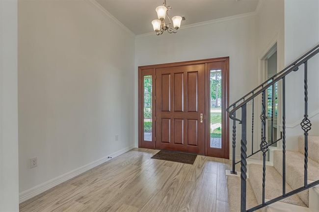 The entry door is flanked by two glass sidelights, allowing natural light to stream in and creating a bright, open, and inviting atmosphere. | Image 9