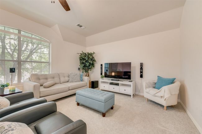 Living area featuring light carpet, plenty of natural light, ceiling fan, baseboards, and lofted ceiling | Image 21
