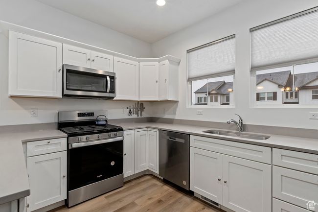 Kitchen with stainless steel appliances, white cabinetry, and sink | Image 10