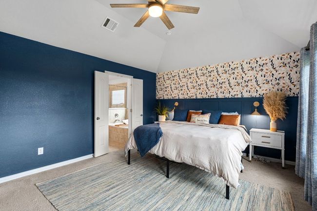 Bedroom with vaulted ceiling, carpet flooring, ensuite bath, a ceiling fan, and baseboards | Image 21