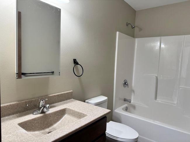 Shared bath between bedrooms features tub/shower combo. | Image 14