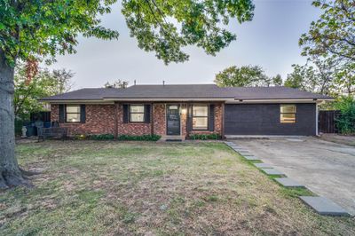 Ranch-style house with a front yard and a converted garage | Image 1