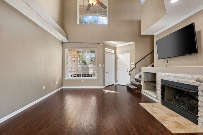 Unfurnished living room featuring wood flooring, mounted tv conveys. | Image 12