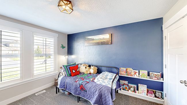 Carpeted bedroom featuring baseboards, a textured ceiling, and visible vents | Image 21