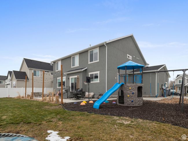 Rear view of property featuring a playground, a residential view, and stucco siding | Image 7