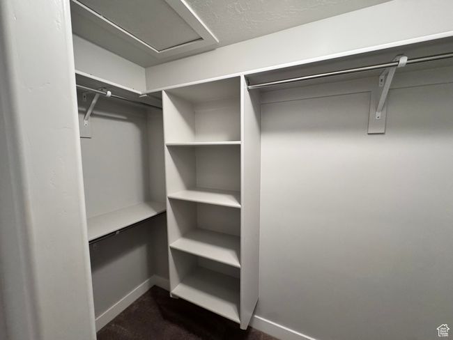 Spacious closet with dark carpet | Image 17