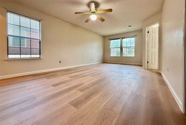 Unfurnished room with light wood-style flooring, ceiling fan, and a textured ceiling | Image 4