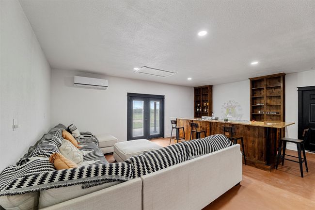 Detached man cave area featuring a wall mounted AC, a textured ceiling, recessed lighting, and bar | Image 38