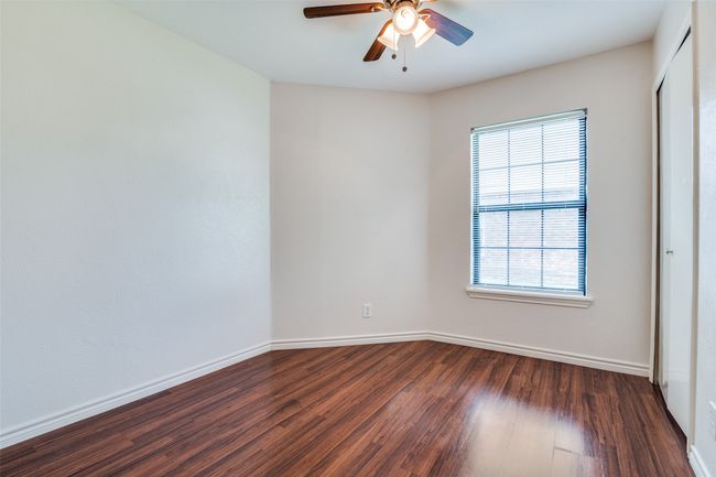 Secondary bedroom with laminate flooring and ceiling fan. | Image 22
