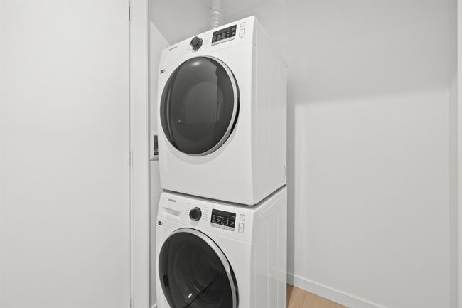 Washroom featuring stacked washer / dryer and light wood finished floors | Image 20