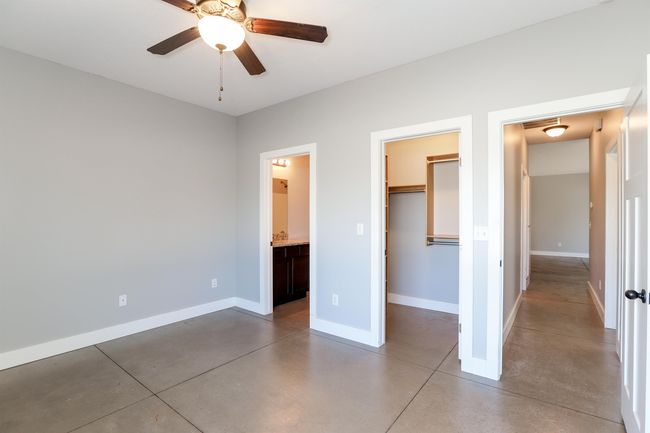 Unfurnished bedroom with a closet, connected bathroom, a spacious closet, and concrete floors | Image 20