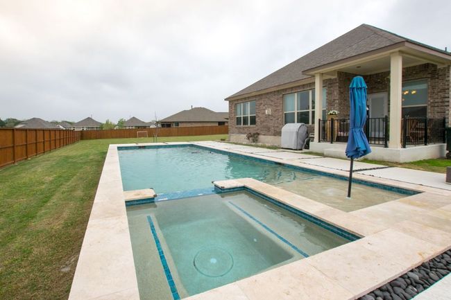 View of pool with a patio, a fenced backyard, a pool with connected hot tub, area for grilling, and a yard | Image 28