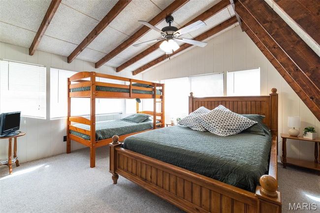 Bedroom with a decorative wall, vaulted ceiling with beams, and ceiling fan | Image 44