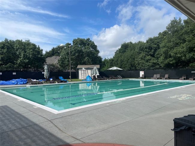 Community pool with a patio area and a storage unit | Image 6