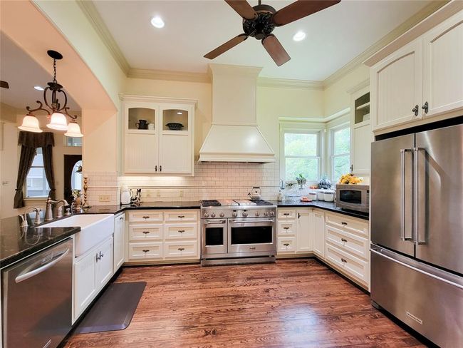 Stunning gourmet kitchen with bright hardwood floors, recessed lighting, and a ceiling fan. | Image 17