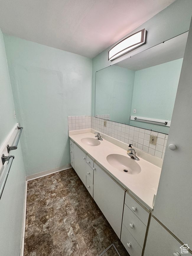 Full bathroom with a sink, backsplash, double vanity, and stone finish flooring | Image 30