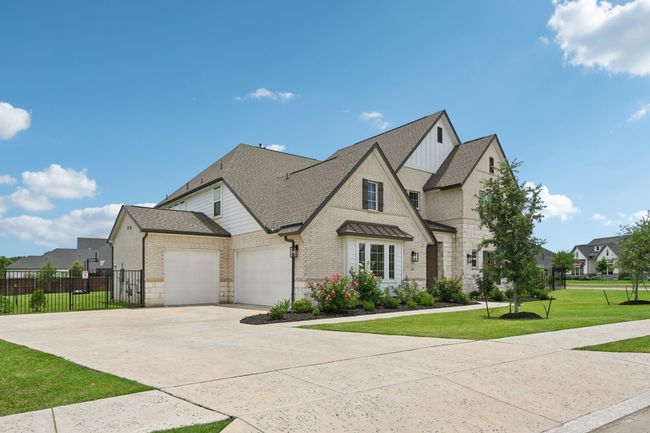 French provincial home with brick siding, a shingled roof, an attached garage, and driveway | Image 5