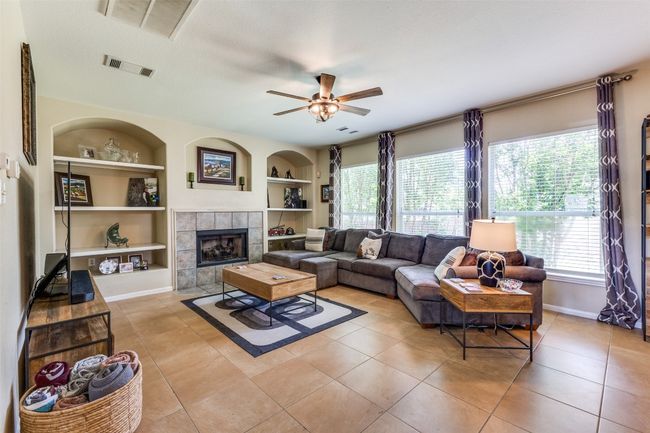 Living room with built in features, a ceiling fan, and light tile patterned flooring | Image 5