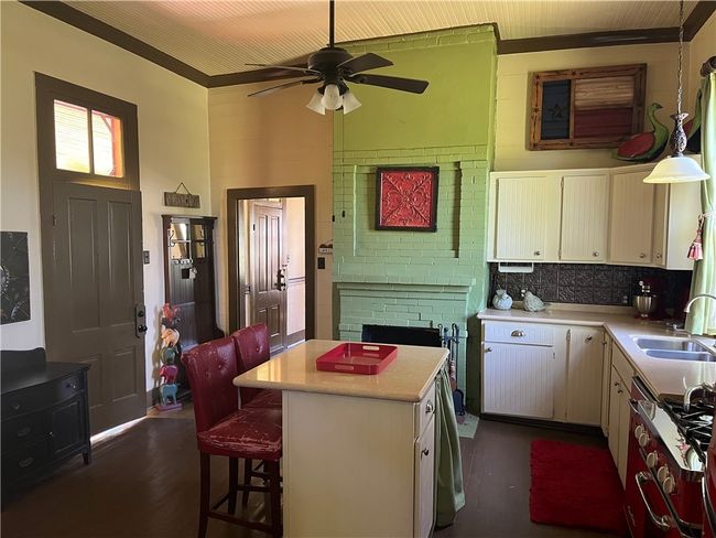 Kitchen center island, a sink, light countertops, and decorative backsplash | Image 20