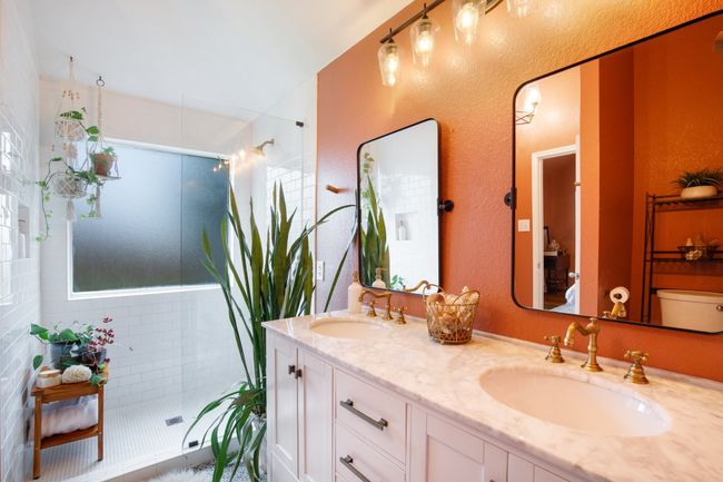 Bathroom featuring tiled shower, double vanity, and a textured wall | Image 16