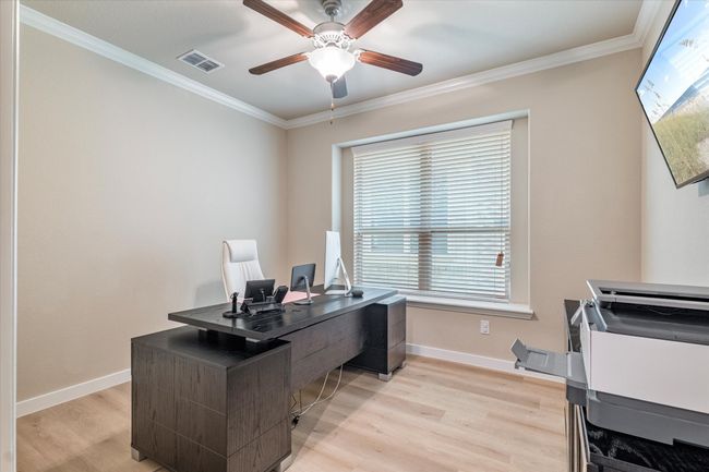 Office area with a ceiling fan, light wood-style floors, ornamental molding, and baseboards | Image 5