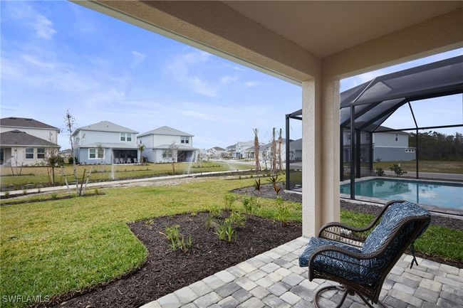 View of yard featuring a lanai, a residential view, an outdoor pool, and a patio | Image 16